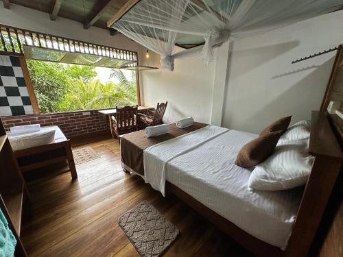 a bedroom with a bed and a table and a window at Verdant Hill Villa in Tangalle