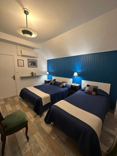une chambre avec deux lits et un mur bleu dans l'établissement Maison D’hôtes, à Argentat
