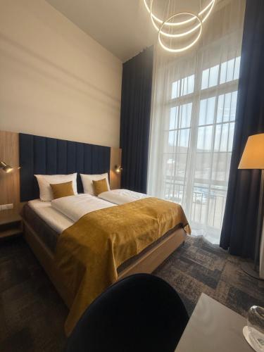 a bedroom with a large bed with a large window at H24 Parkhotel Thale in Thale