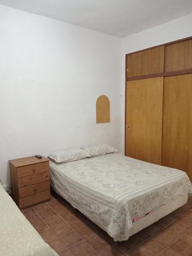 een slaapkamer met 2 bedden en een houten kast bij Del sur in Mar de Ajó