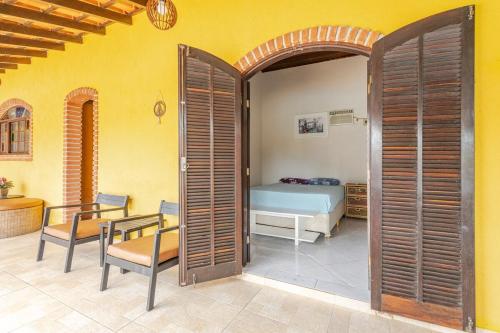 a bedroom with a bed and a table and a table and chairs at Casa moderna no Morada da Praia - Conforto, Estilo e Pet Friendly in Bertioga