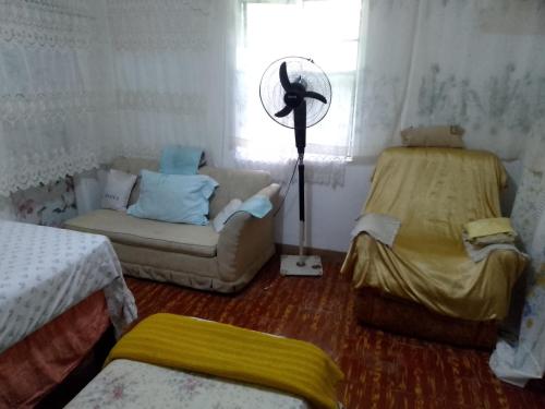 Una sala de estar con un sofá y un ventilador. en Captain Morgan House, en Kingston