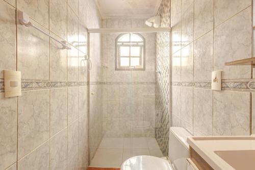 a bathroom with a shower and a toilet and a sink at Casa moderna no Morada da Praia - Conforto, Estilo e Pet Friendly in Bertioga