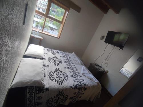 a small bedroom with a bed and a television at Calli Yoloiztac in Cedro