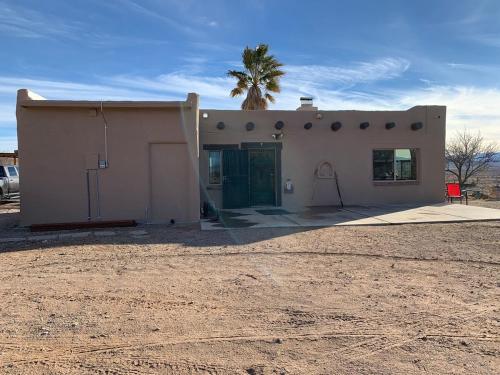 a small house with a palm tree in front of it at Indian Ridge Casita in Willcox