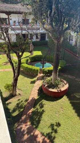 a garden with two trees and a swimming pool at Hotel Calli Yoloiztac, Valle de bravo in Valle de Bravo