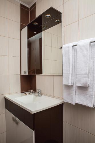a bathroom with a sink and a mirror and towels at Topalovi Guest House in Zlatograd