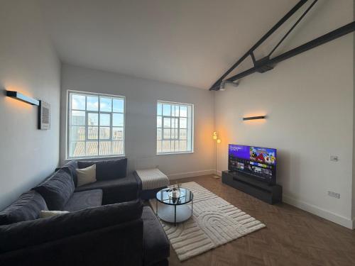 a living room with a couch and a flat screen tv at Cosy one bedroom flat in the heart of Chelmsford in Chelmsford