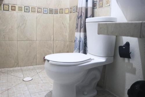 Posada Casa Tortuga, Zipolite في زيبوليت: مرحاض أبيض في حمام مع دش