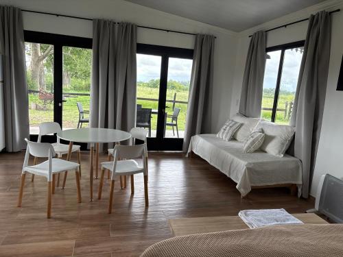 a bedroom with a bed and a table and chairs at Aires de Capilla in Capilla del Señor