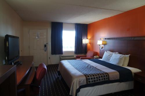 une chambre d'hôtel avec un lit et une télévision à écran plat dans l'établissement Howard Johnson by Wyndham Perry GA, à Perry