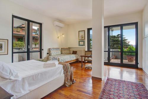 a bedroom with a bed and a living room with a couch at Appartamento Il Parco Cernobbio in Cernobbio