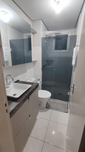 a bathroom with a shower and a toilet and a sink at Apartamento completo e com ar-condicionado in Bento Gonçalves