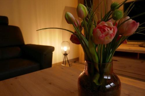 un vase rempli de fleurs sur une table dans le salon dans l'établissement Suite Am Radweg, à Pittenbach
