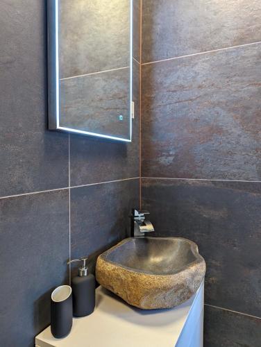 a bathroom with a stone sink and a mirror at Funktastic Central Maksimir Condo in Zagreb