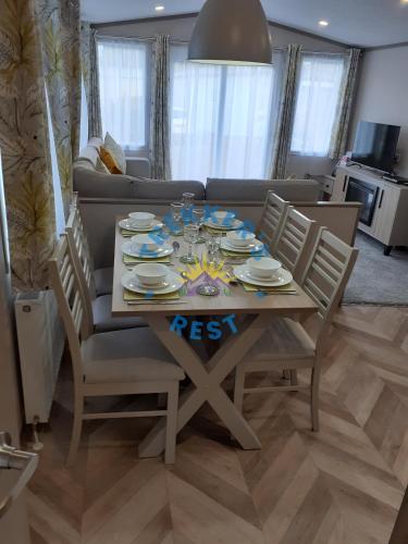 a dining room table with chairs and a couch at Trekkers Rest, Brigham, Cockermouth, Cumbria in Cockermouth