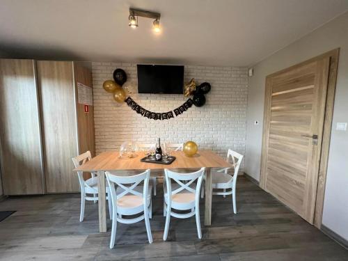 une salle à manger avec une table en bois et des ballons dans l'établissement BIESZCZADZKI RAJ Komfortowe domy z kominkami i Sauną na obiekcie, à Olchowiec