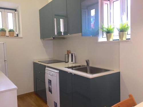 a kitchen with a sink and some windows at Apartments Center Lisboa in Lisbon