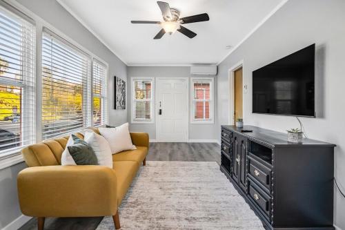 a living room with a couch and a flat screen tv at 1BD Remodeled Craftsman Cottage Free parking Heart of lIttle Italy in San Diego