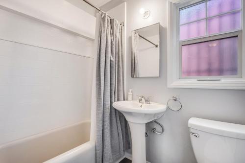 a white bathroom with a sink and a toilet and a window at 1BD Remodeled Craftsman Cottage Free parking Heart of lIttle Italy in San Diego