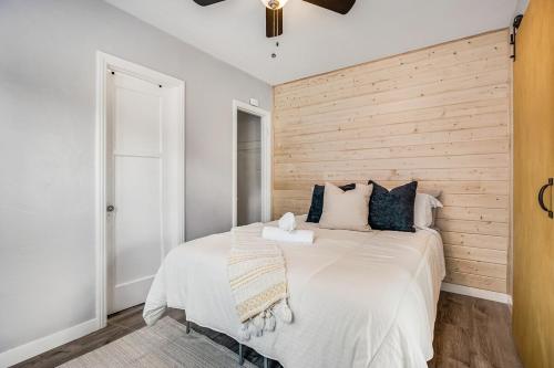 a bedroom with a large bed with a wooden wall at 1BD Remodeled Craftsman Cottage Free parking Heart of lIttle Italy in San Diego