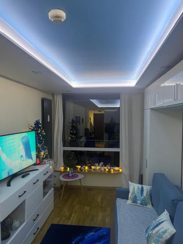 a living room with a tv and a blue ceiling at Apartament NIEBO Ustroń in Ustroń