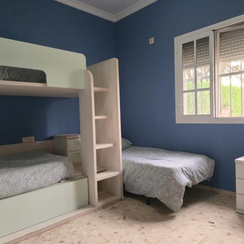 a bedroom with two bunk beds and a window at CHALET VILLA MARÍA ANTONIA in Cantillana