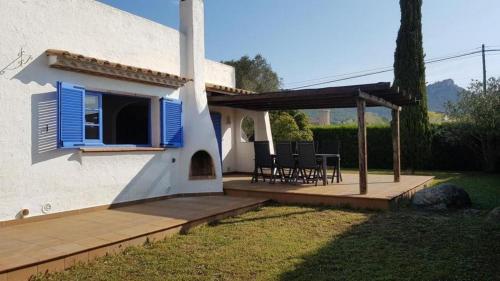 a house with a deck with a blue shutter at Acacies 25 in Torroella de Montgrí
