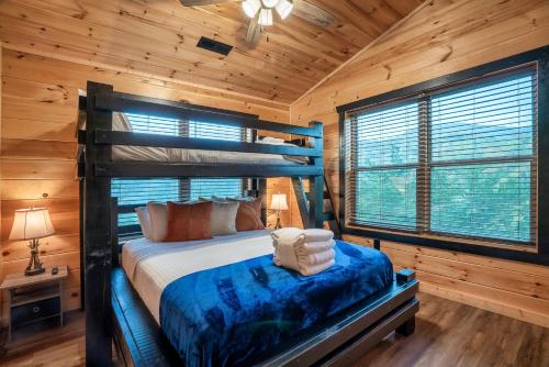 a bedroom with a bunk bed in a log cabin at Smoky Mountain Cabin, Sleeps 12, 2 Kitchens & Hot Tub in Pigeon Forge
