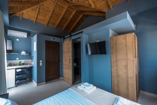 a blue bedroom with a bed and a sink at Anthelia in Skala Potamias