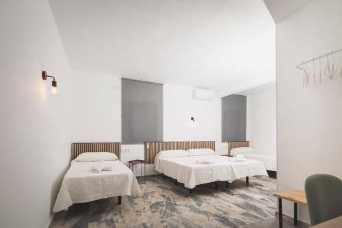 a hospital room with two beds and a mirror at Hotel Rural Macondo in Trujillanos