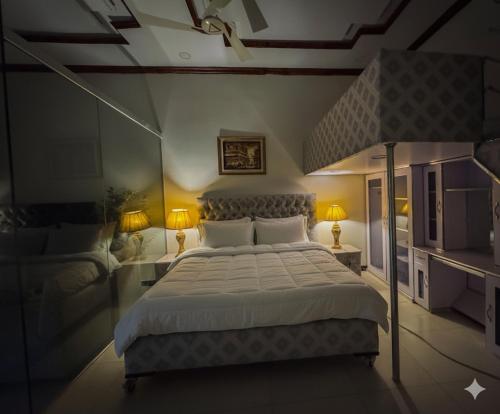 a bedroom with a large bed and two lamps at The Orchard Haven in Islamabad
