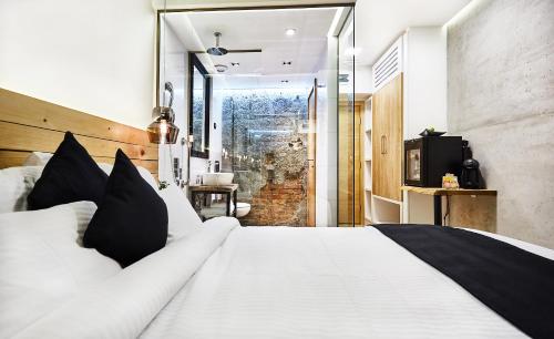 a bedroom with a large white bed with black pillows at One Luxury Suites in Belgrade