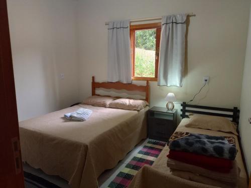 En eller flere senge i et værelse på Chalé São Matheus