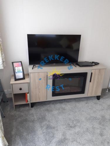 a flat screen tv on top of a entertainment center at Trekkers Rest, Brigham, Cockermouth, Cumbria in Cockermouth