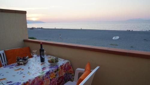 une table avec une bouteille de vin sur la plage dans l'établissement Terrazza Sul Mare, à Terme Vigliatore