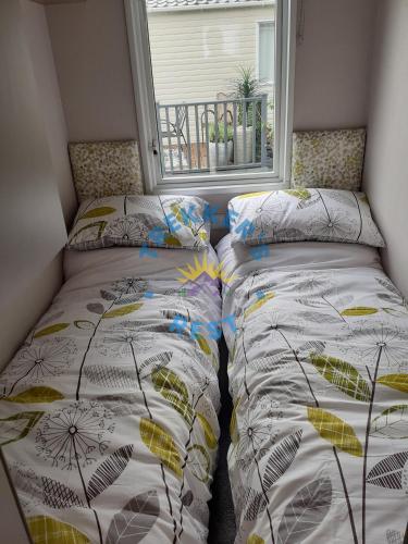 a bedroom with two beds and a window at Trekkers Rest, Brigham, Cockermouth, Cumbria in Cockermouth