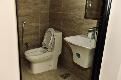 a bathroom with a toilet and a sink at Four Stays Khobar in Al Khobar