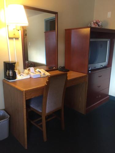 a desk in a hotel room with a television at West Motel in Freeport