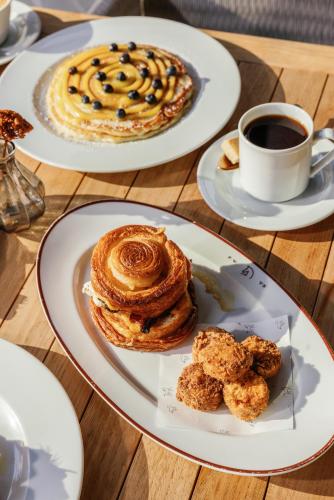una mesa con dos platos de bollería y una taza de café en Bowie House, Auberge Collection, en Fort Worth