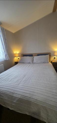 a bedroom with a large white bed with two lamps at Our Sea View - Heysham in Heysham