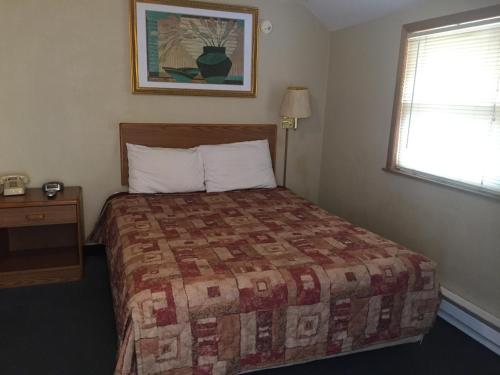 a hotel room with a bed and a window at West Motel in Freeport