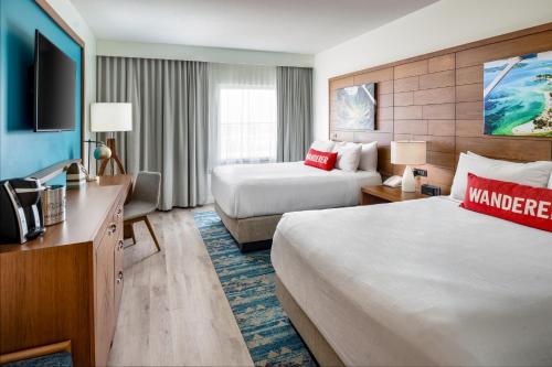 Compass Hotel Beaufort by Margaritaville في Beaufort: غرفة فندقية بسريرين وتلفزيون