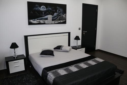 a bedroom with a large bed with white sheets and pillows at Vivenda Paraíso in Candelária