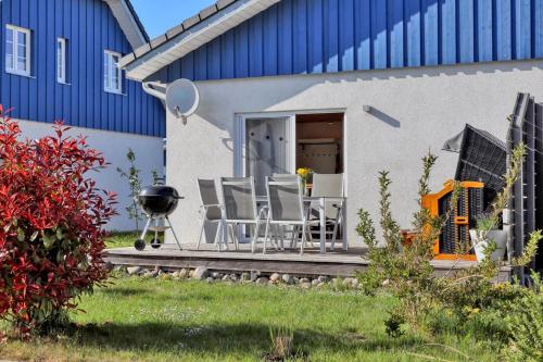 eine Terrasse mit Stühlen und einem Grill vor einem Gebäude in der Unterkunft Ferienhaus La Mer in Altefähr