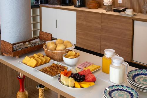 Una mesa con una variedad de comida sobre ella en Vila Hayô, en Passo de Camarajibe