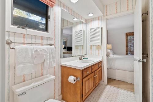 a bathroom with a sink and a toilet and a bed at IC106: 106 Inlet Cove in Kiawah Island