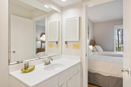 a white bathroom with a sink and a bed at IC50: 50 Inlet Cove in Kiawah Island