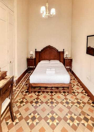 a bedroom with a bed and a checkered floor at 1900 Backpacker's Hostel in Lima