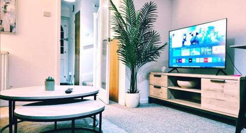 ein Wohnzimmer mit Tisch und Fernseher in der Unterkunft Modern 2-bed , Bradley Stoke, NR Parkway Station, Free Parking in Bristol